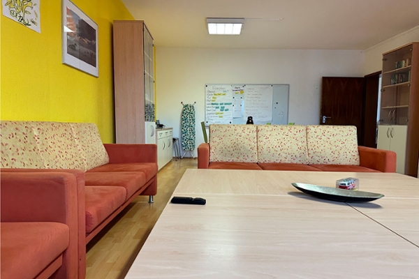 Blick in den Gruppenraum. Im Vordergrund eine Sitzlandschaft in Hintergrund ein Tisch mit Stühlen und eine Pinnwand. Blick in den Gruppenraum. Im Vordergrund eine Sitzlandschaft in Hintergrund ein Tisch mit Stühlen und eine Pinnwand.
