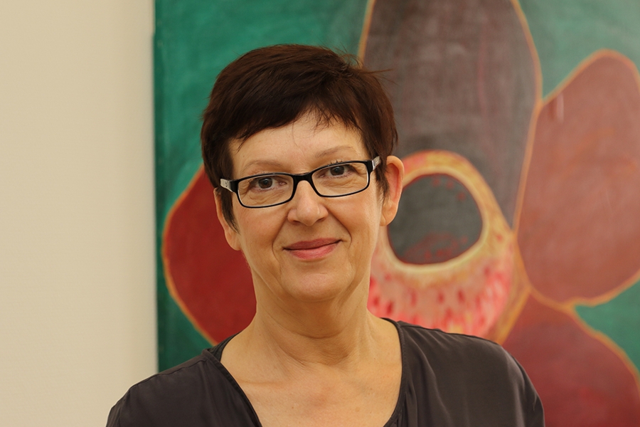 Portraitfoto von Sozialtherapeutin Doris Braun vor einem Gemälde